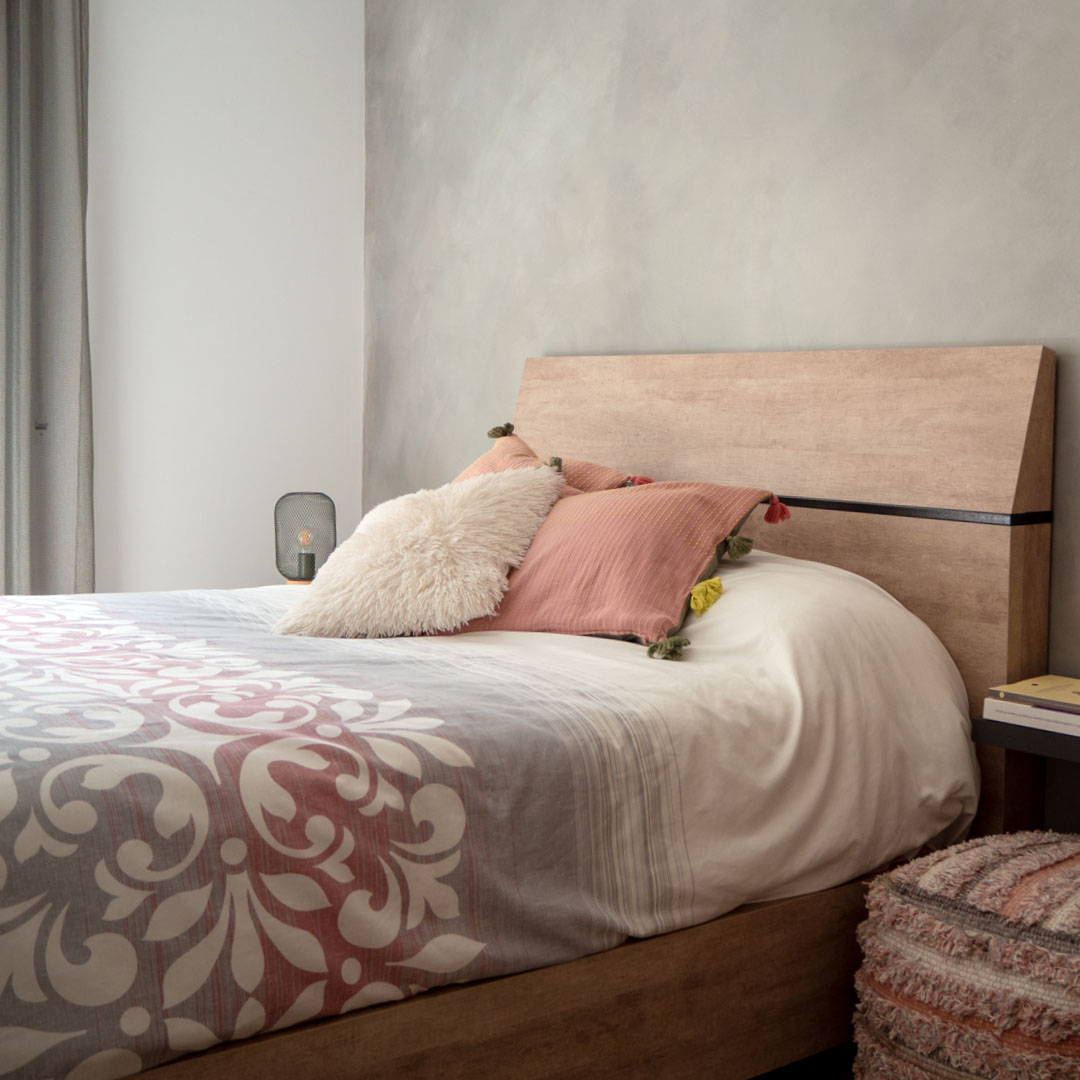 capçal de llit de fusta i coixins decoratius amb tons rosa