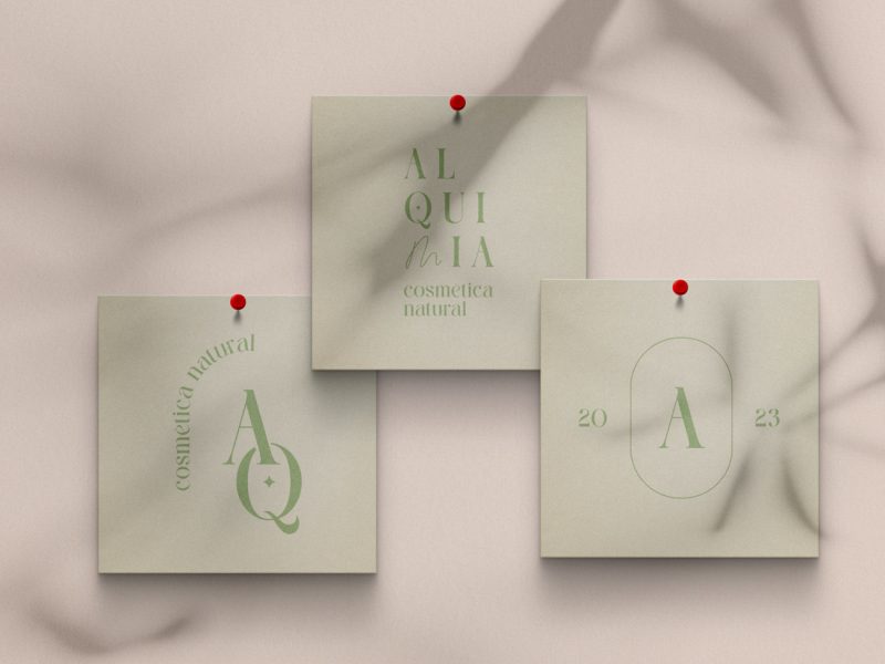 Tres cartolines enganxades amb xinxetes a una paret amb les versions secundàries de logotip d'alquímia en color verd