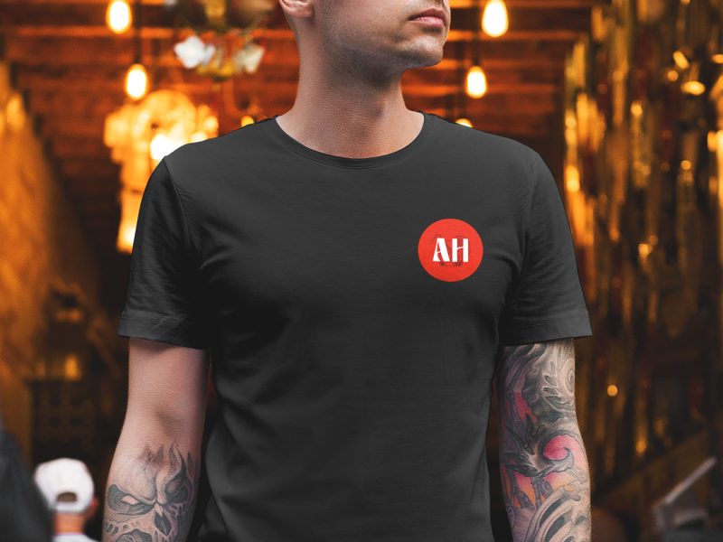 Cambrer amb una camiseta negra i el simbol d'After Hours amb un bar al fons