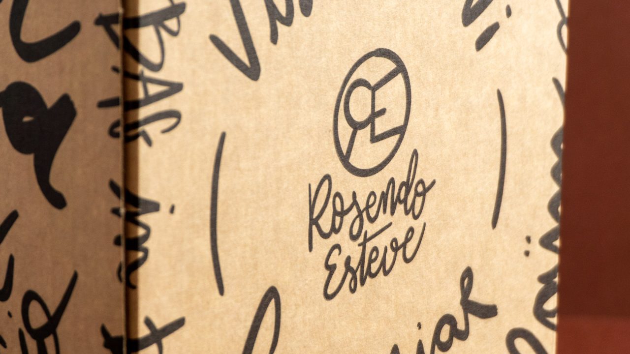 Detall del logotip de Rosendo Esteve amb lettering sobre una caixa i un fons marró