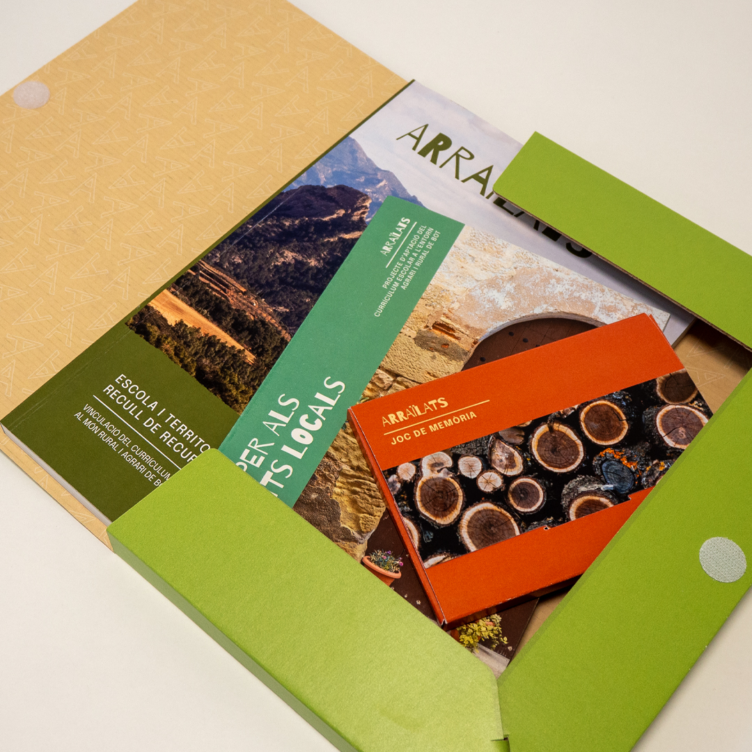 Carpeta de color verd amb un llibre, una guia i una caixa dins